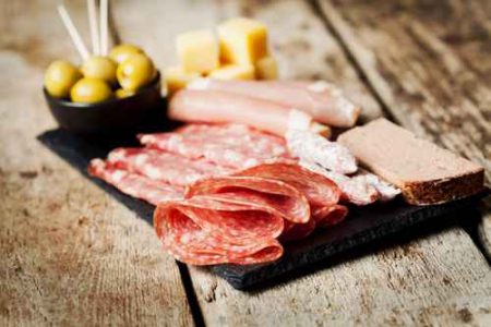 Charcuterie assortment and olives on wooden background
